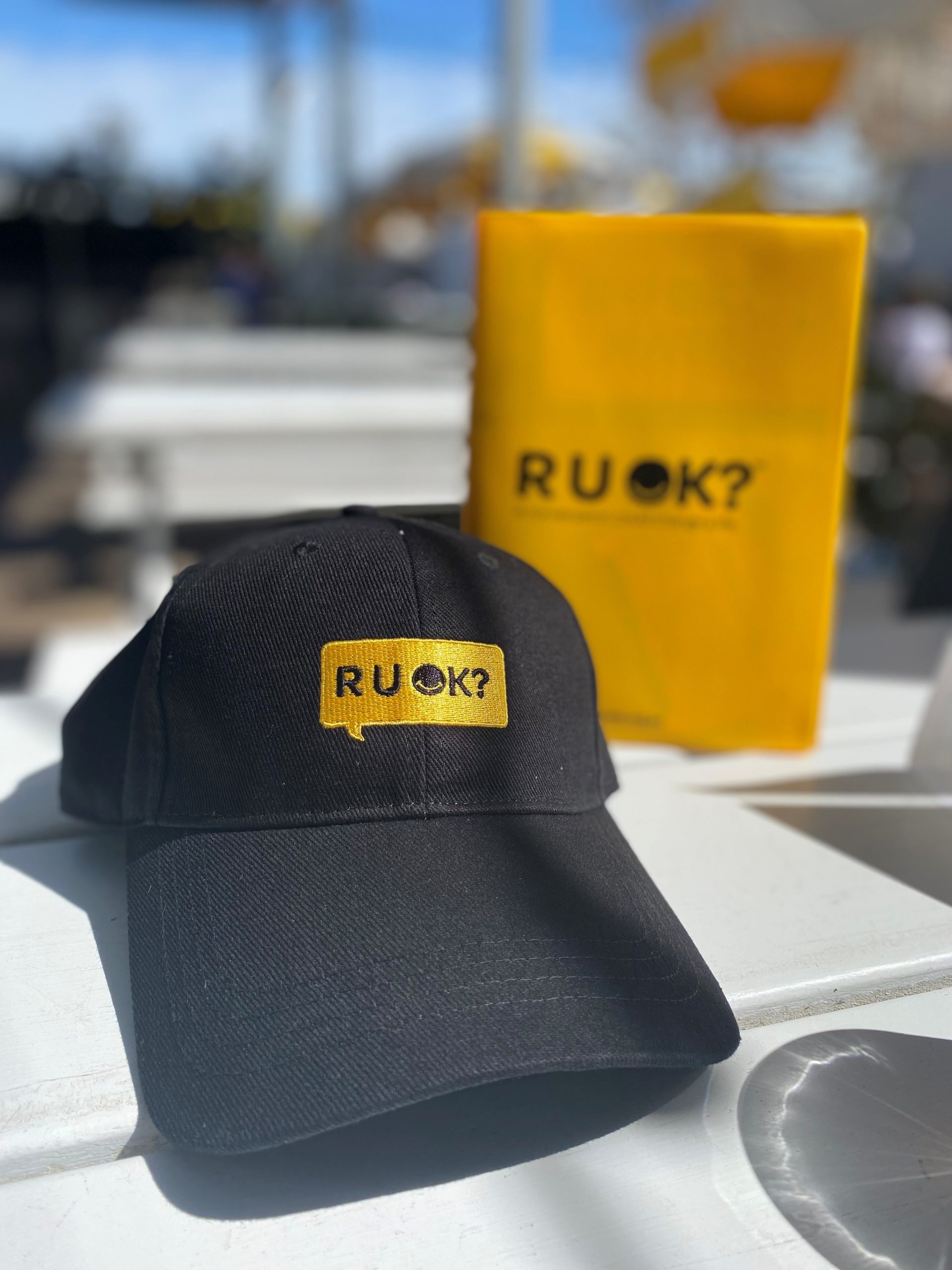 black cap with R U OK? written on it in yellow text