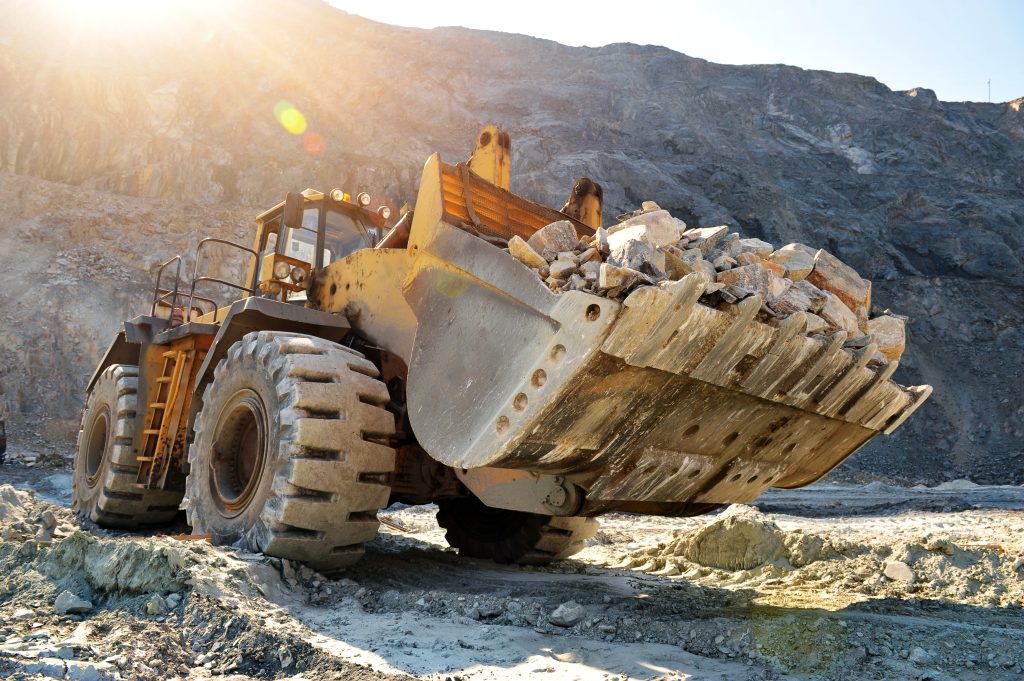 wheel loader machine unloading rocks in the open-mine of iron ore